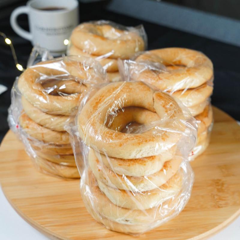 Packaged biscuits on wooden board with coffee mug.
