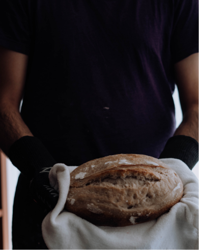Person holding freshly baked bread.