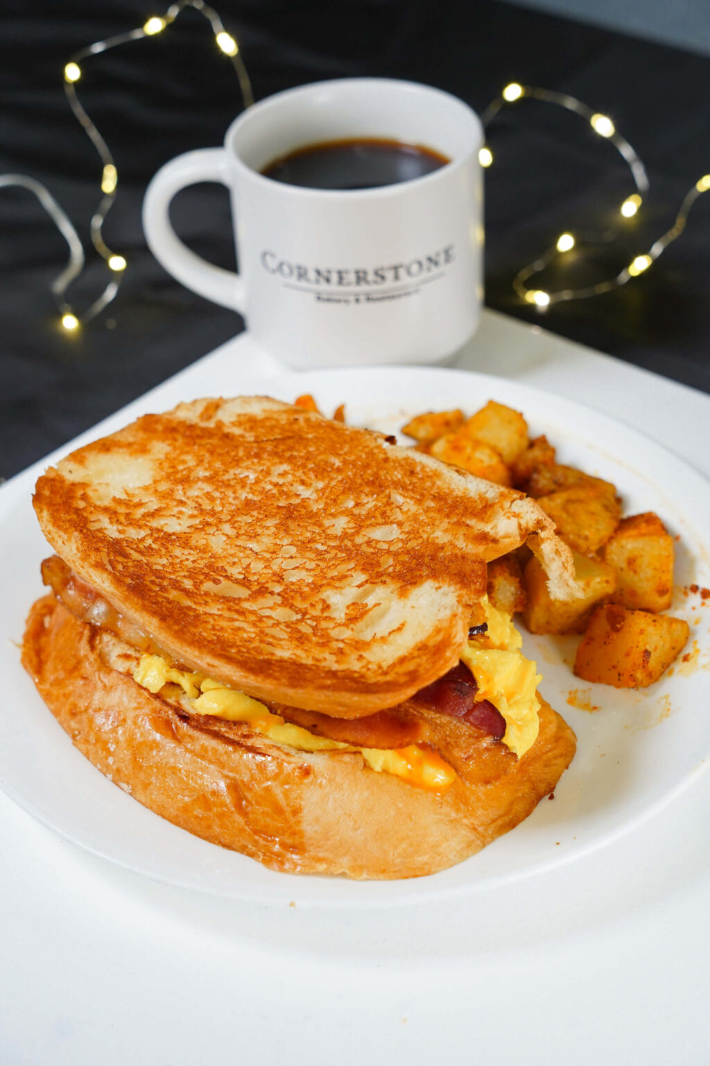 Breakfast sandwich with coffee and festive lights